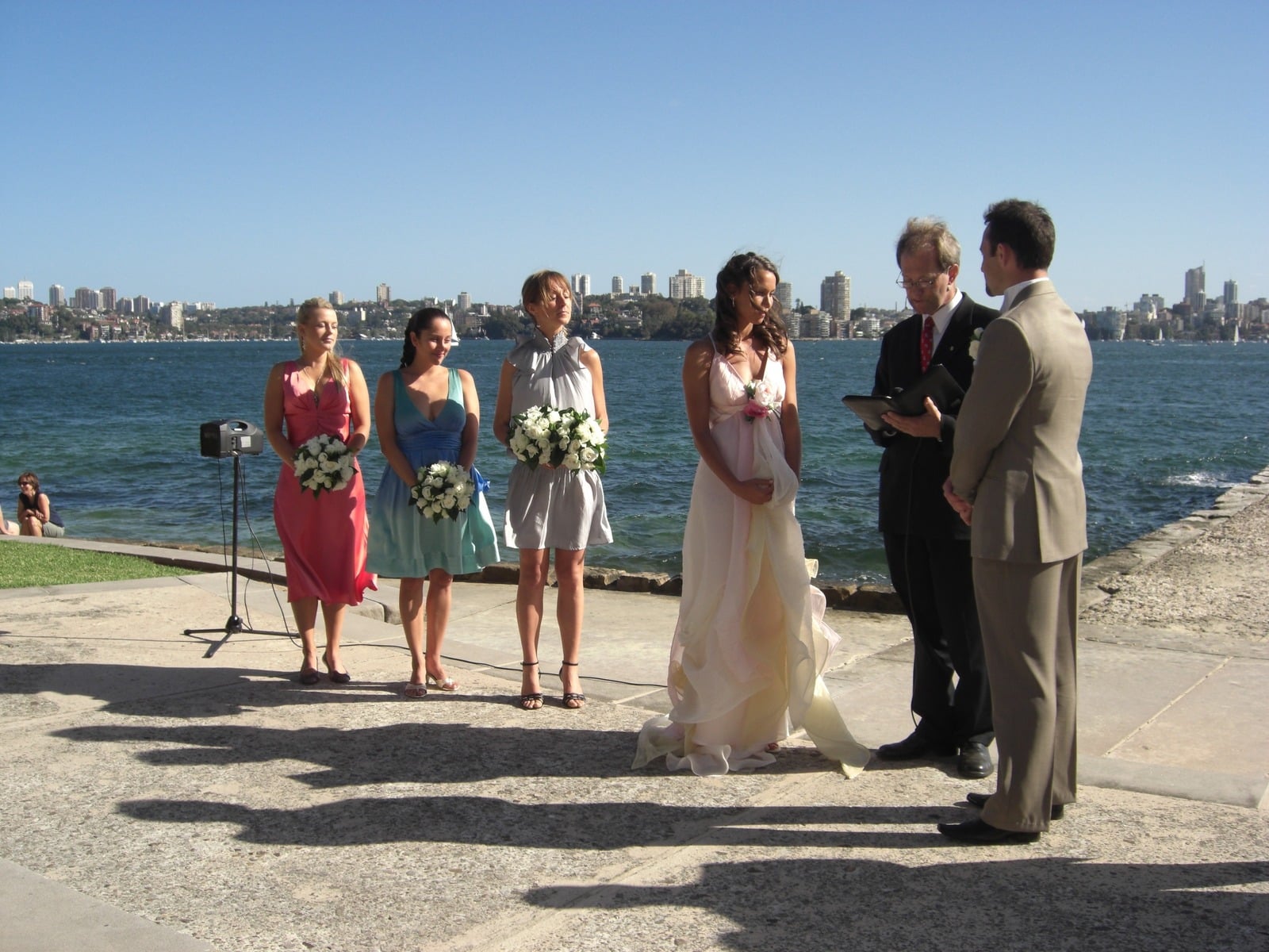 Bride, groom and officiant at an outdoor waterfront ceremony at Bradleys Head, Sydney NSW
