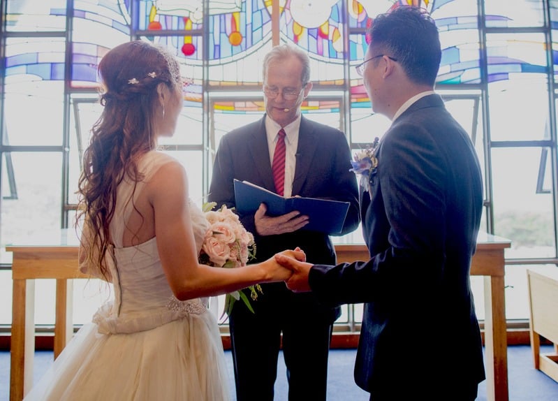 Bride and groom holding hands at the altar of The Coast Chapel at Little Bay, Sydney NSW