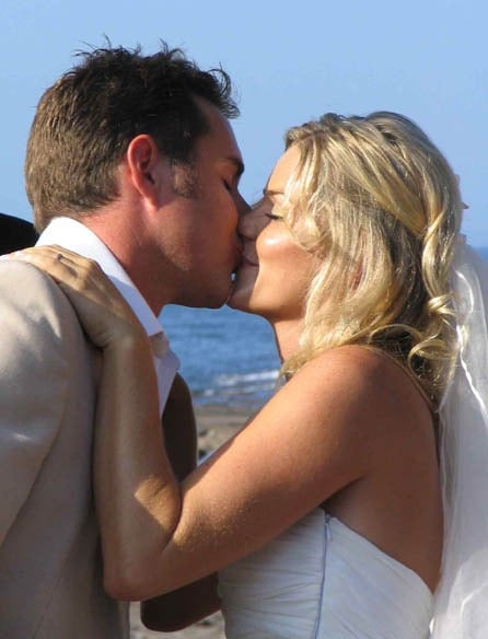 Bride and groom sharing a kiss at a beach wedding