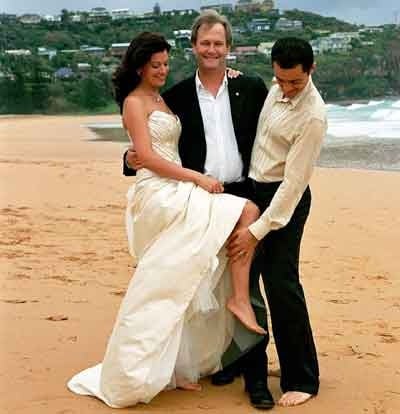 Bride, celebrant and groom during a beach wedding ceremony at Whale Beach, NSW